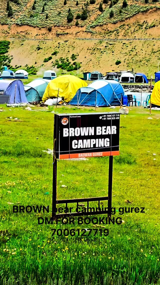 Tents on a green meadow surrounded by mountains in Gurez